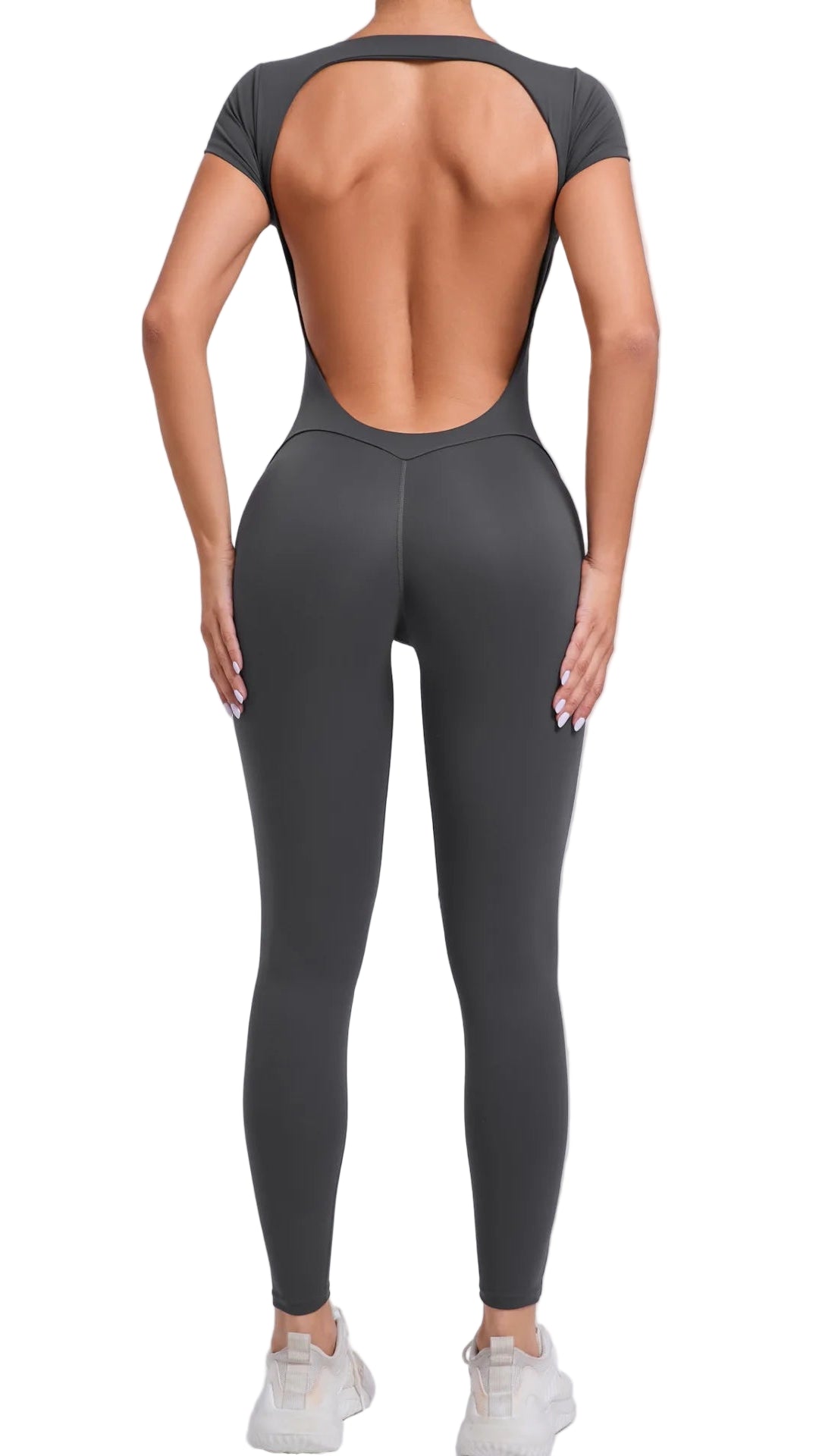 Person wearing a gray open-back top and leggings on a light gray background