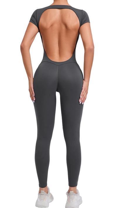 Person wearing a gray open-back top and leggings on a light gray background